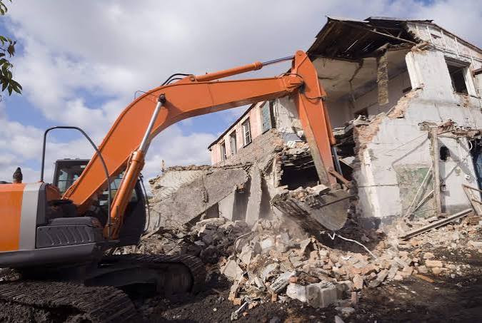 Heavy duty high-reach demolition equipment tearing down concrete