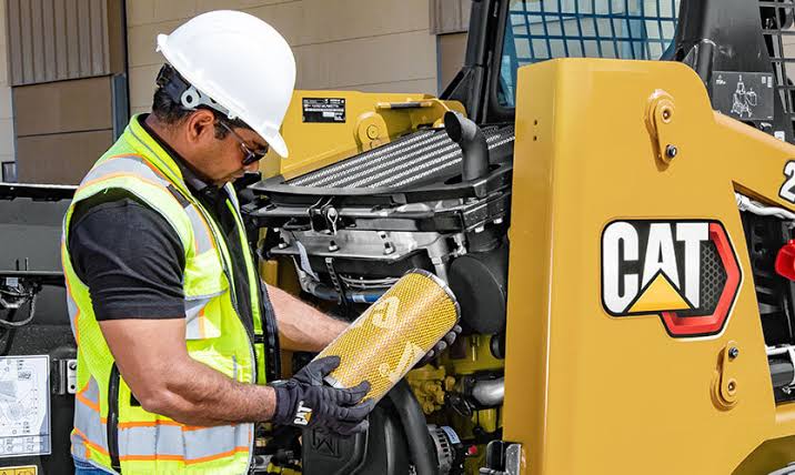 Technician conducting field service maintenance on heavy machinery